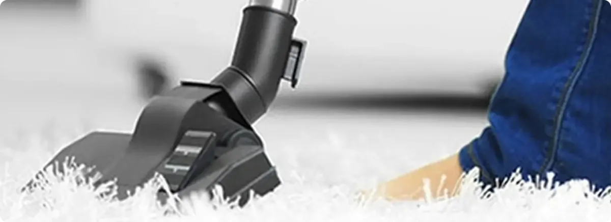 Close-up of a professional vacuuming a white carpet in Saint James City.